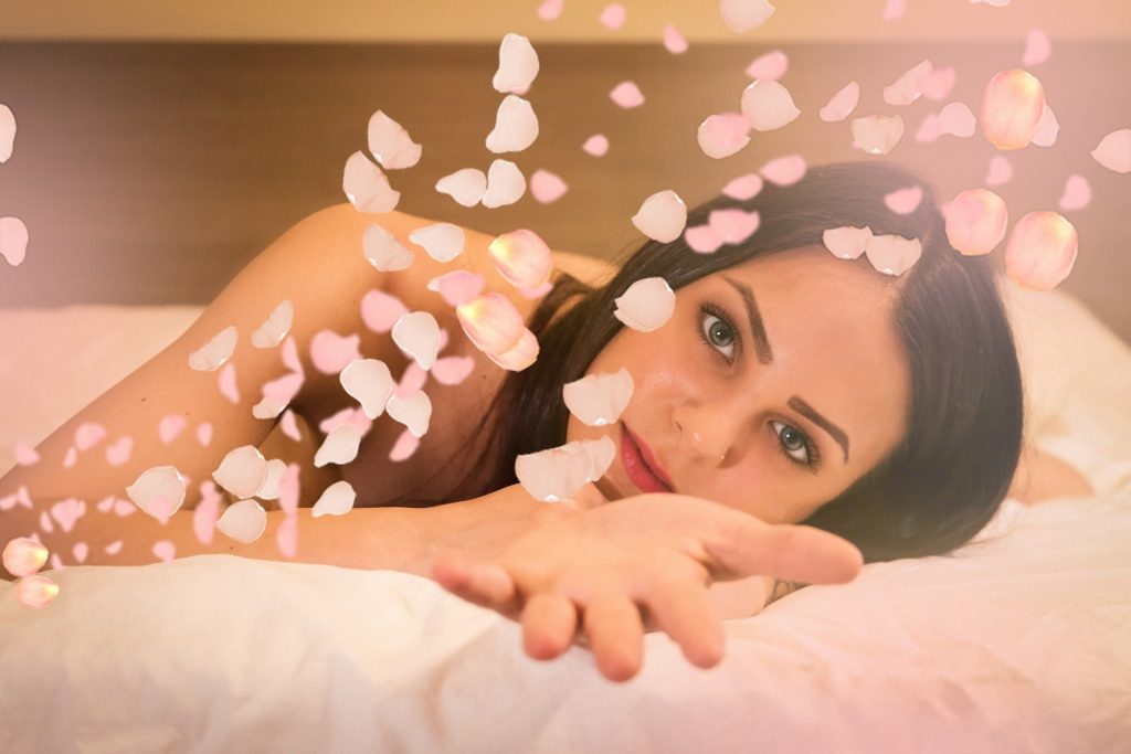 Mulher deitada na cama com rosas para uma massagem do Dia dos namorados