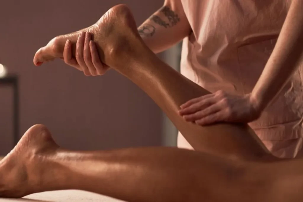 Massagem profissional na panturrilha e pé com óleo, ideal para aliviar a dor e cansaço nas pernas.