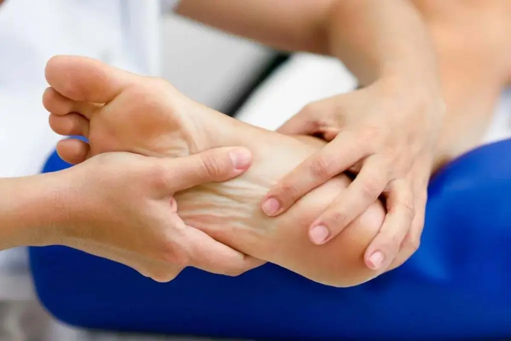 Pessoa massageando o pé de um paciente