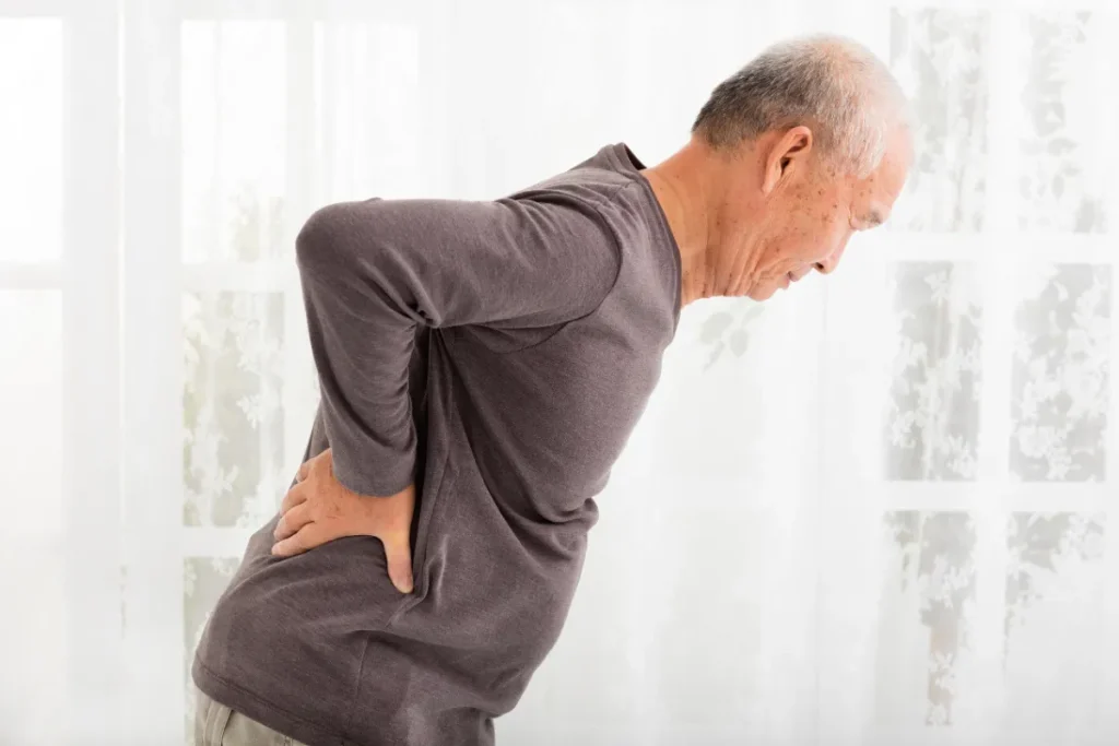 Senhor meio inclinado, com as mãos nas costas